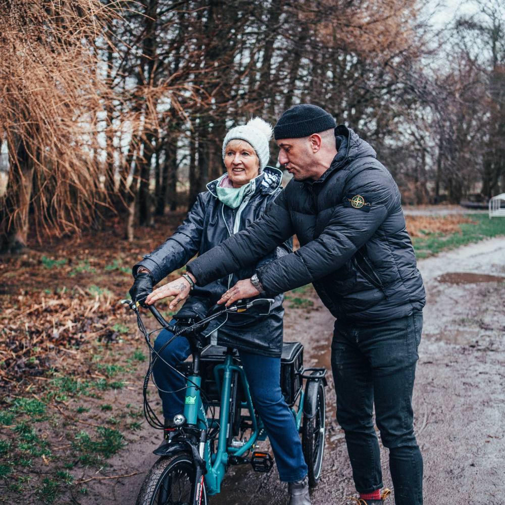 How does an electric tricycle help with balance issues?